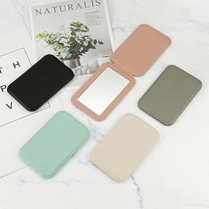 Portable folding PU leather makeup mirrors in five colors on marble background