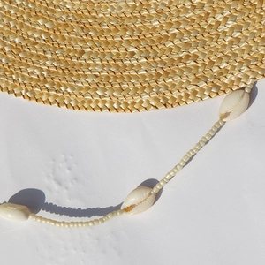 Vista macro della trama del cappello di paglia con decorazione di collana di conchiglie