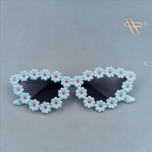 Detail of light blue daisy flower frames on toddler sunglasses with dark grey lenses