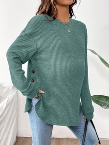 Close-up of dark green ribbed maternity top featuring side buttons and crew neckline