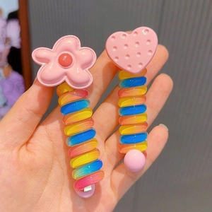 Close-up of colorful spiral hair clips with cute pink flower and heart toppers