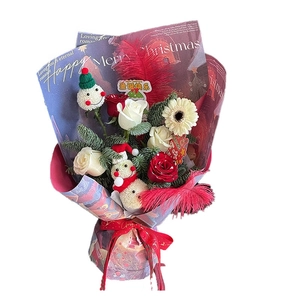 Christmas bouquet with red roses, cute snowmen dolls and festive wrapping paper