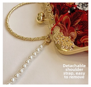 Détail de la bandoulière en perles amovible et fermoir en métal doré sur le sac rouge