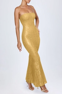 Close-up of sparkling gold sequins and fishtail hem on strapless evening dress