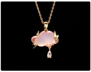 Detail of pink cloud pendant necklace with golden lightning bolt and drop crystal charm