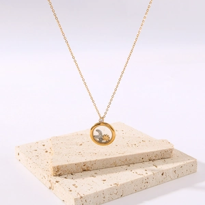 18K gold plated necklace with a circular glass pendant featuring floating moon and star charms
