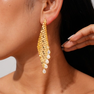 Boucles d'oreilles franges en maille plaqué or 18 carats avec zircons sur un mannequin