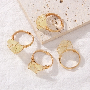 Macro detail of handmade wire-wrapped yellow crystal rings with irregular natural gemstones