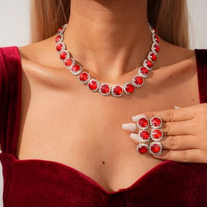 Detail of model wearing a vintage layered crystal and red gemstone necklace and earrings