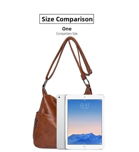 Brown faux leather crossbody bag size comparison with a tablet on a white background