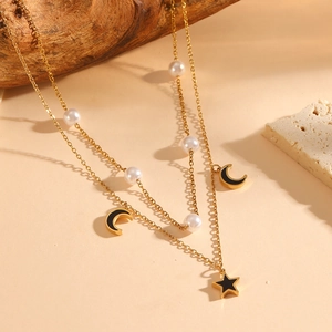 Double-layered golden necklace with white pearls and black moon star pendants
