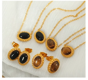 Macro shot of vintage gold necklaces and earrings with tiger eye and black onyx stones