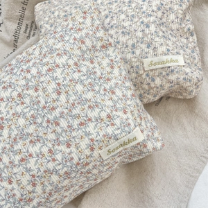 Dettaglio ravvicinato della borsa cosmetica in velluto a coste floreale con texture
