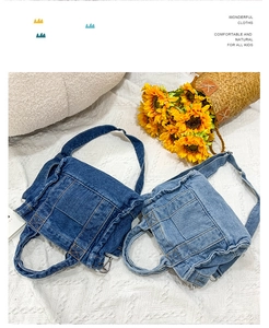 Detail of dark and light blue denim crossbody bags with adjustable straps on white fabric