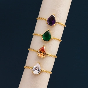 Quatre bagues chaîne ajustables plaquées or 18k avec cristaux colorés en goutte