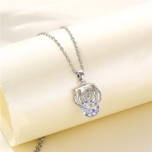 Silver tone rose pendant necklace with a large round zircon stone on light beige background