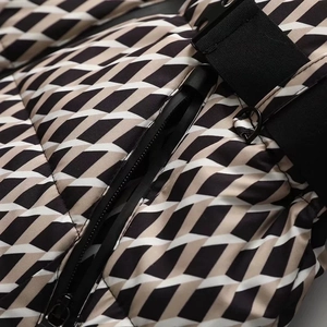 Close-up of geometric pattern ski jacket with high-quality metal zipper and black waist belt
