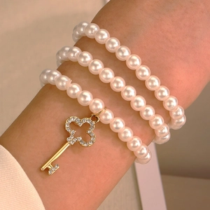 Bracciale a tre strati di perle con ciondolo a chiave a quadrifoglio dorato da donna