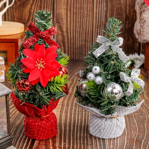 Mini red and silver Christmas trees with bows and ornaments on dark wood tabletop