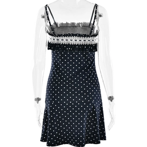 Close-up of navy blue polka dot mini dress with white lace trim and ruffle back details