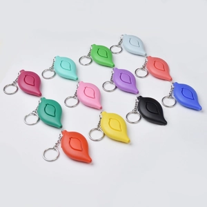 Flat lay of colorful leaf-shaped personal alarms on white background for security