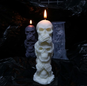 Three-stack skull candle detail with see-no-evil design on gothic black background