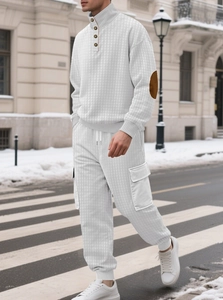 Détail du survêtement matelassé blanc pour homme avec coudières brunes en décor urbain