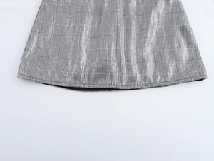 Gros plan sur une jupe à carreaux gris avec paillettes et détails de couture finis