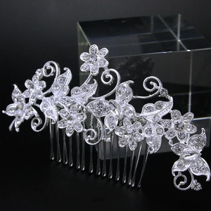 Detail of silver bridal hair comb with pearls and rhinestones on a black background