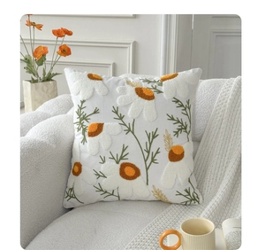 Detailed view of orange 3D tulip embroidery on a white square farmhouse cushion cover
