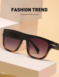 Close-up of oversized gradient sunglasses with silver arrow detail on a geometric stand
