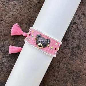 Handmade pink woven bracelet with sparkly rhinestone bear mascot and stylish tassels