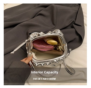 Detail showing internal capacity of the silver pleated cloud bag with daily essentials