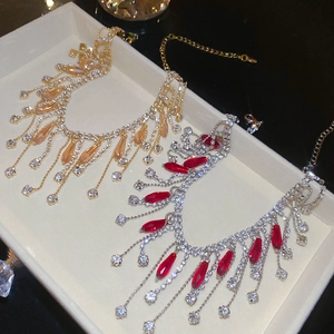 Detail of luxury crystal tassel necklaces in gold with champagne and silver with red stones