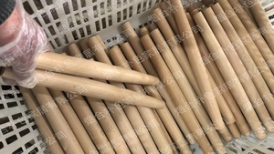 Close-up of solid wood rolling pins with natural grain texture in a workshop