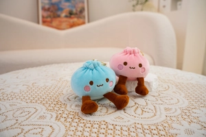 Detail of pink and blue plush bun charms with cute faces on a lace tablecloth