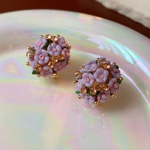 Detailaufnahme rosa und lila Blumen-Ohrstecker mit funkelnden champagnerfarbenen Kristallen