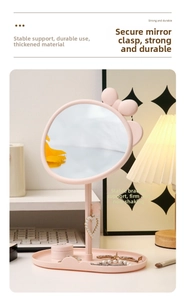 Detail of cute pink desktop makeup mirror with bow decor and jewelry storage base