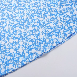 Detail of blue floral print fabric showing white small flowers and neat stitching quality