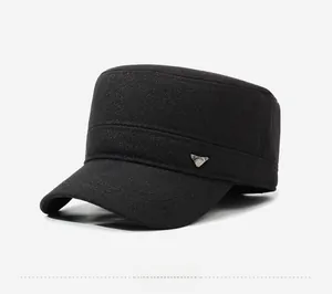 Close-up of black cadet army hat with metallic triangular badge and textured fabric