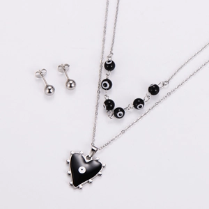 Close-up of double-layered necklace with black heart pendant and evil eye beads and studs
