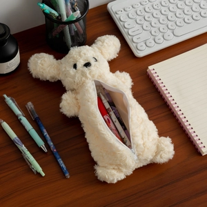 Trousse à crayons chien en peluche teddy avec fermeture éclair sur le bureau
