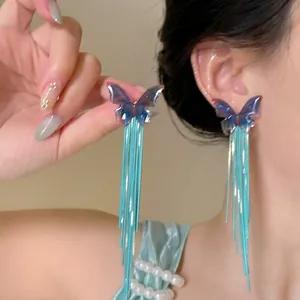 Detail of teal butterfly long tassel earrings with shimmering snake chains on ear