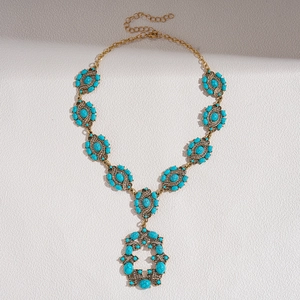 Vue détaillée du collier bohème en bronze avec résine turquoise et pendentif fleur ajouré
