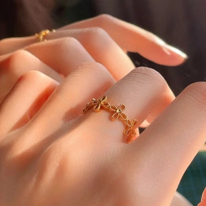 Gold plated open ring with hollow clover pattern and vintage beaded edge on a finger