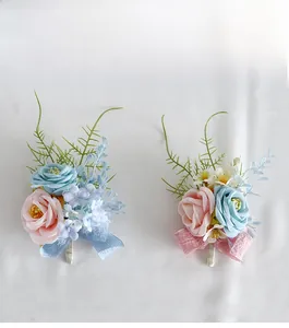 Detail of elegant wedding corsages with blue and pink camellias and satin ribbons
