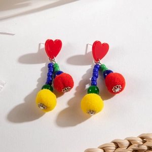 Detail of colorful pompom earrings with red heart studs and beaded tassel accents