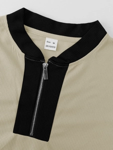 Detail of khaki waffle knit texture with black contrast zipper and size M label
