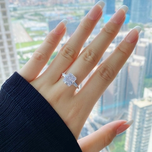 On-hand display of a square pink zircon ring with tapered side stones and silver band