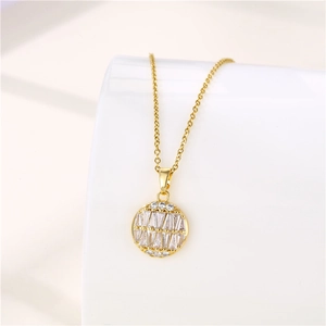 Detailed view of a gold circular pendant with micro-pave cubic zirconia on a white surface